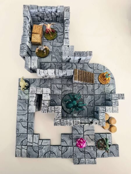 Diorama de combat JDR avec figurines d'aventuriers et araignée géante dans un donjon modulaire 3D, décor de salle détaillé avec escaliers et tonneaux, Les Trésors du Donjon.