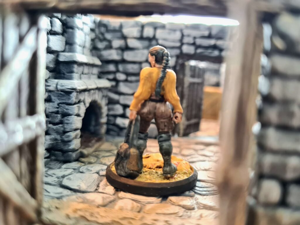 Vue cinématique d'une figurine de barbare franchissant une porte de donjon en pierre, décor miniature impression 3D brossage à sec, ambiance médiévale fantastique JDR, Les Trésors du Donjon.