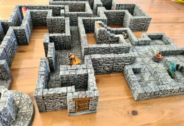 Grand donjon modulaire en impression 3D pour JDR, labyrinthe de murs en pierre avec portes et escaliers, système OpenLock, figurines 28mm-32mm sur décor peint.
