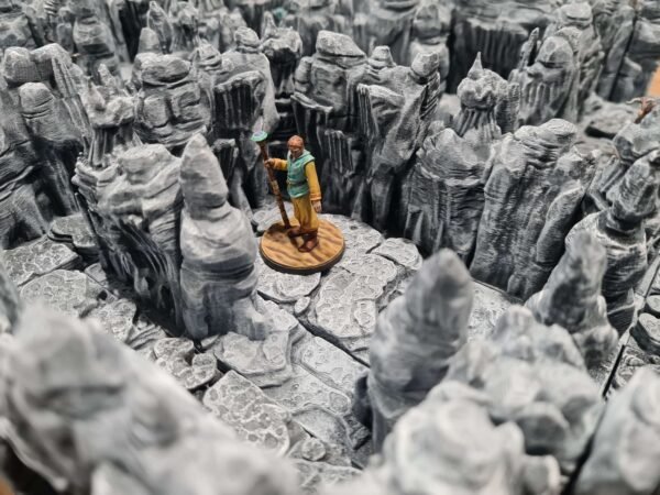 Décor de grotte fantastique en impression 3D, rochers escarpés et stalagmites pour JDR, figurine de mage sur dalles de pierre, Les Trésors du Donjon.