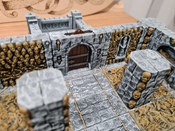 Donjon JDR sur mesure — décors gothiques avec crânes dorés, porte en bois et murs en pierre PLA+