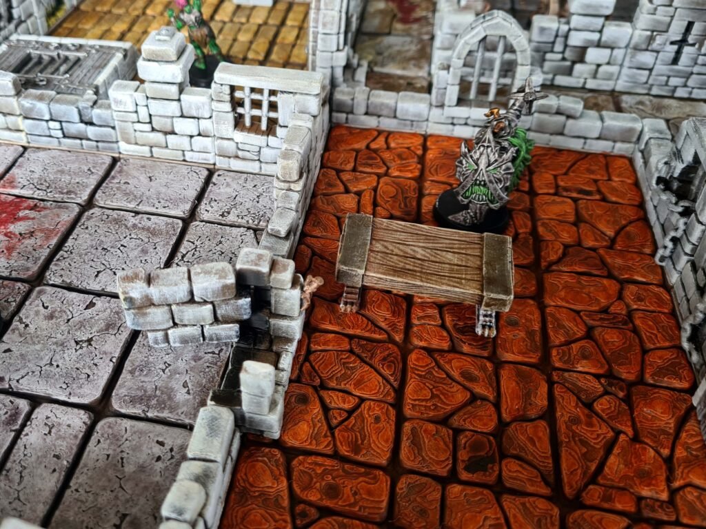 Intérieur de donjon 3D avec dalles de sol rouges texturées, table en bois détaillée et murs de pierre modulaires.