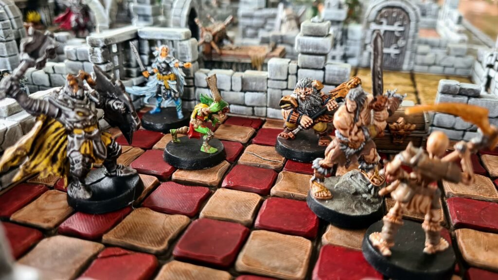Groupe de figurines HeroQuest (Barbare, Nain, Enchanteur) en combat sur un plateau de donjon 3D magnétique avec dalles rouges et coffre au trésor.