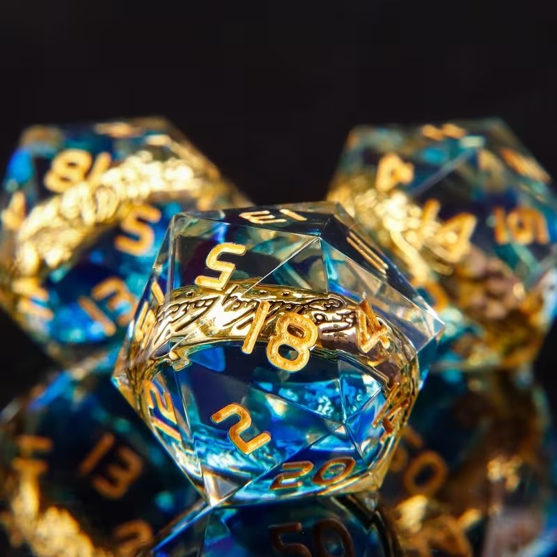 Dé D20 en résine bleue transparente avec anneau unique doré gravé et chiffres dorés